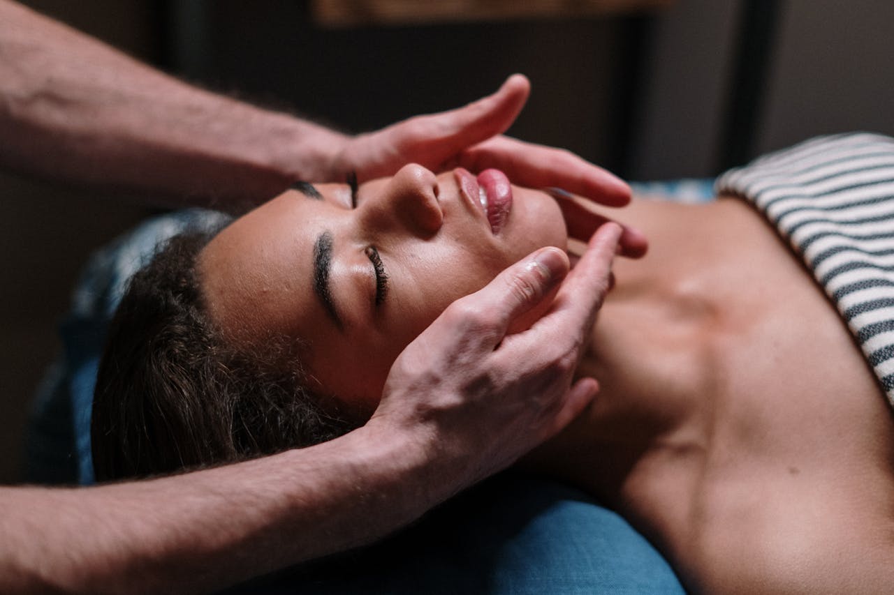 Close-up of a woman receiving a soothing facial massage in a serene spa environment.